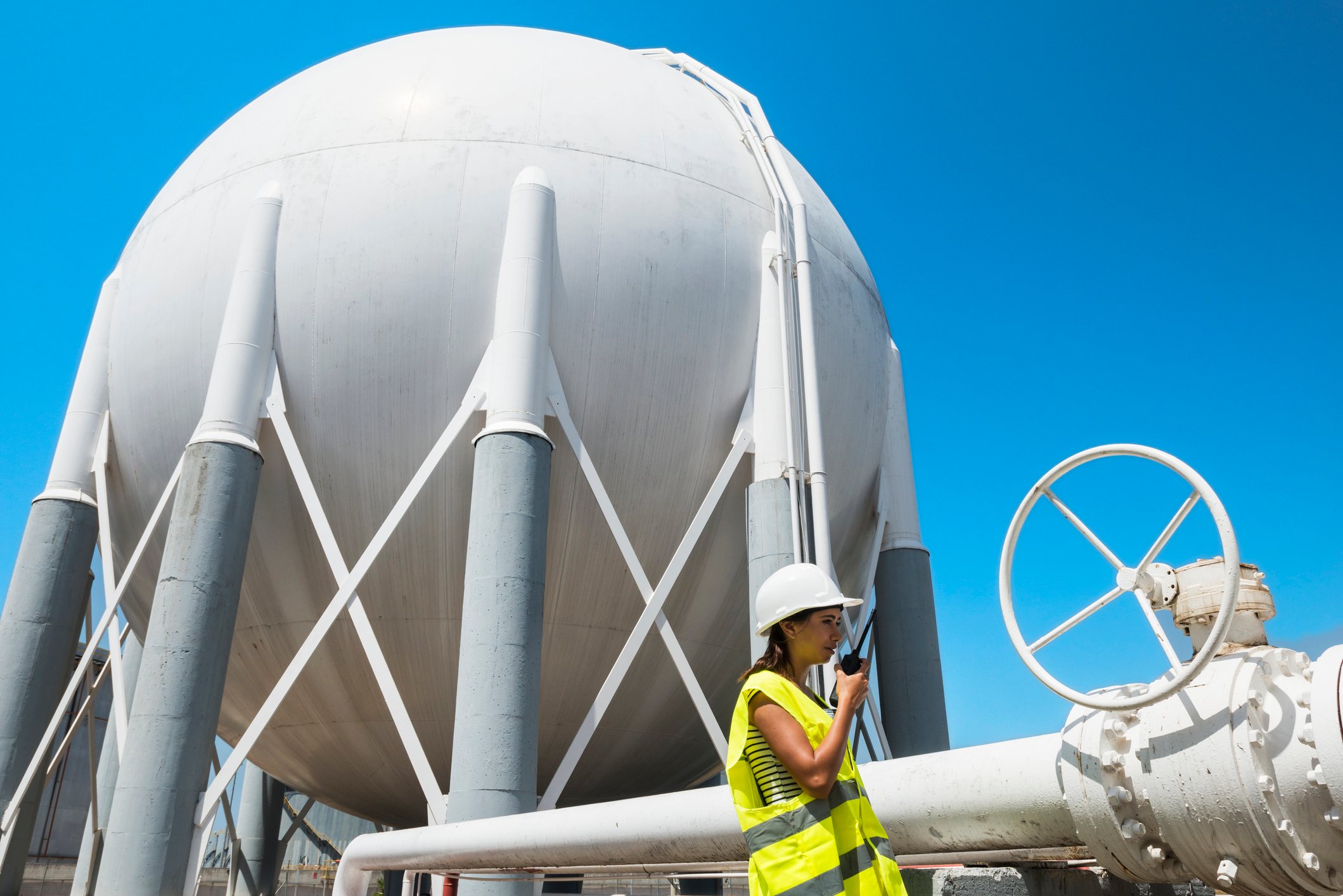 Worker in front of storage tank.