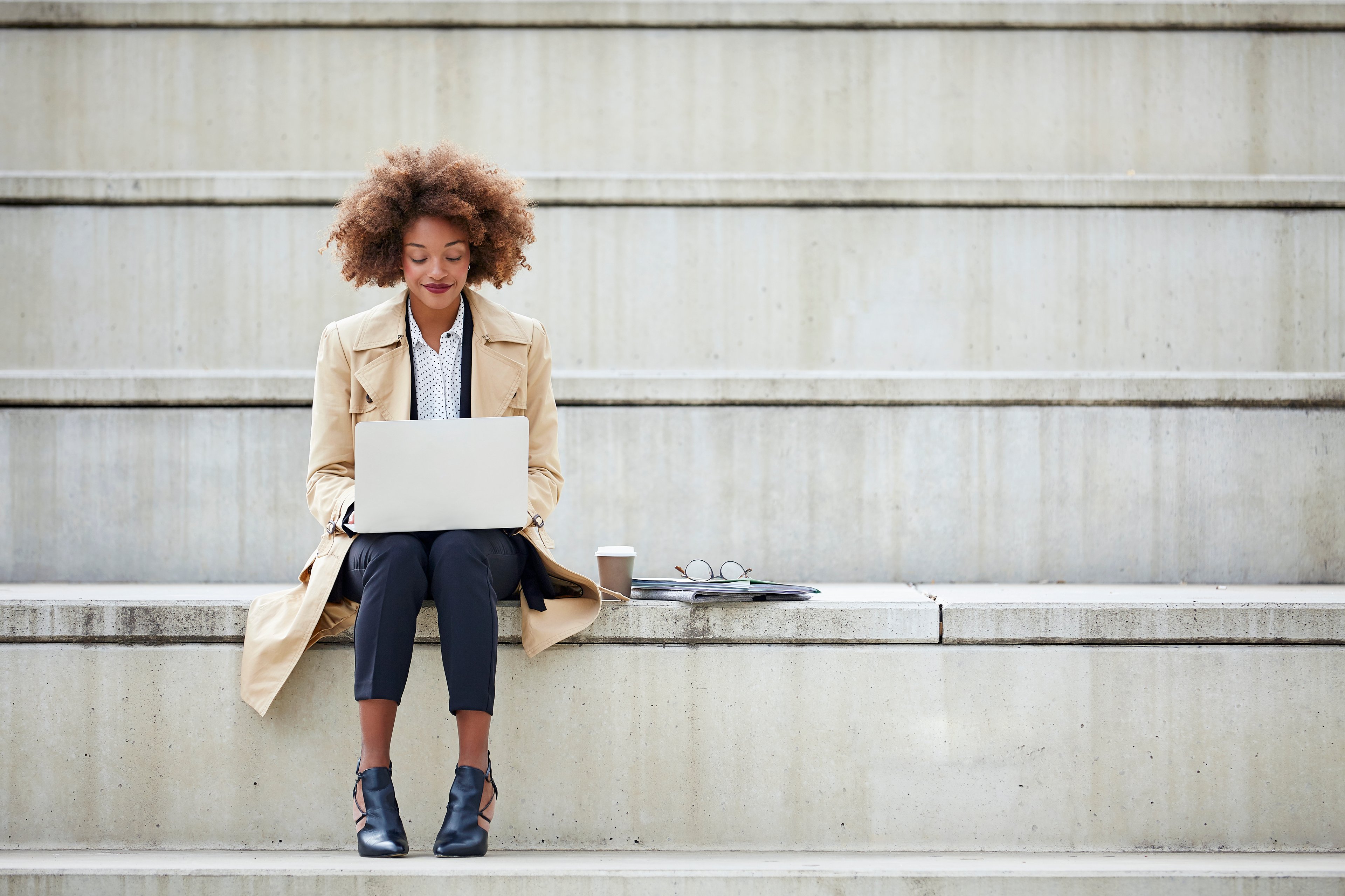 Person sitting on steps using laptop
