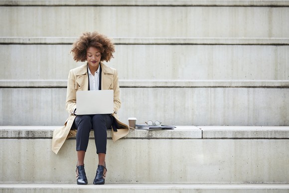 Person sitting on steps using laptop
