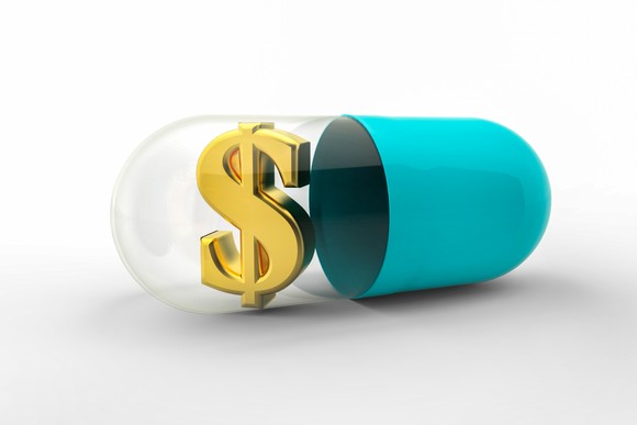 A pill with a golden dollar sign in it.