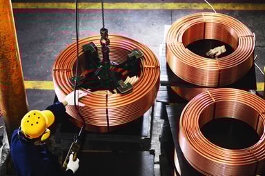 A worker tests copper coils.