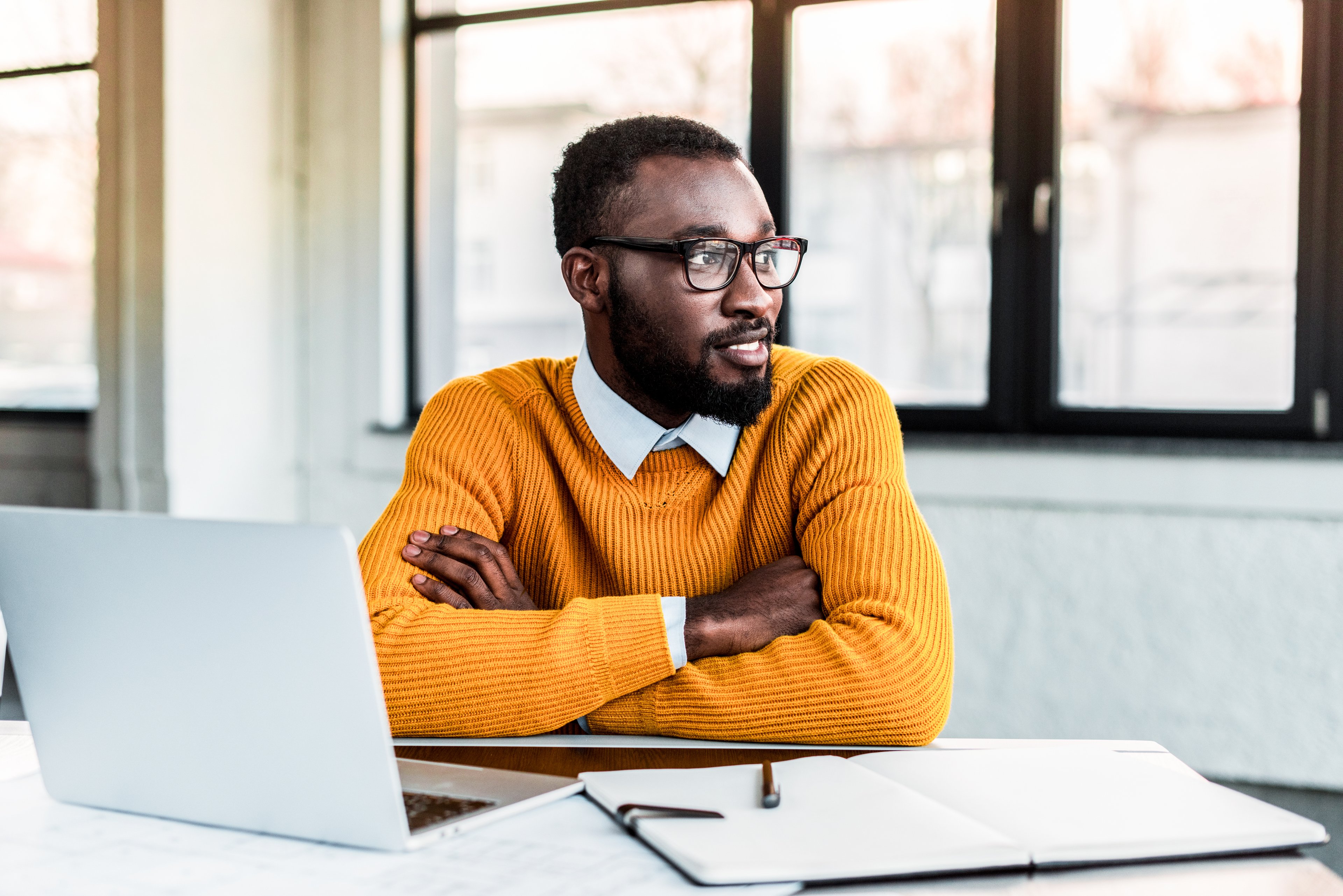 A smiling businessperson sitting at a desk.