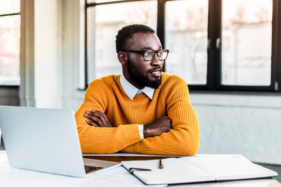A smiling businessperson sitting at a desk.