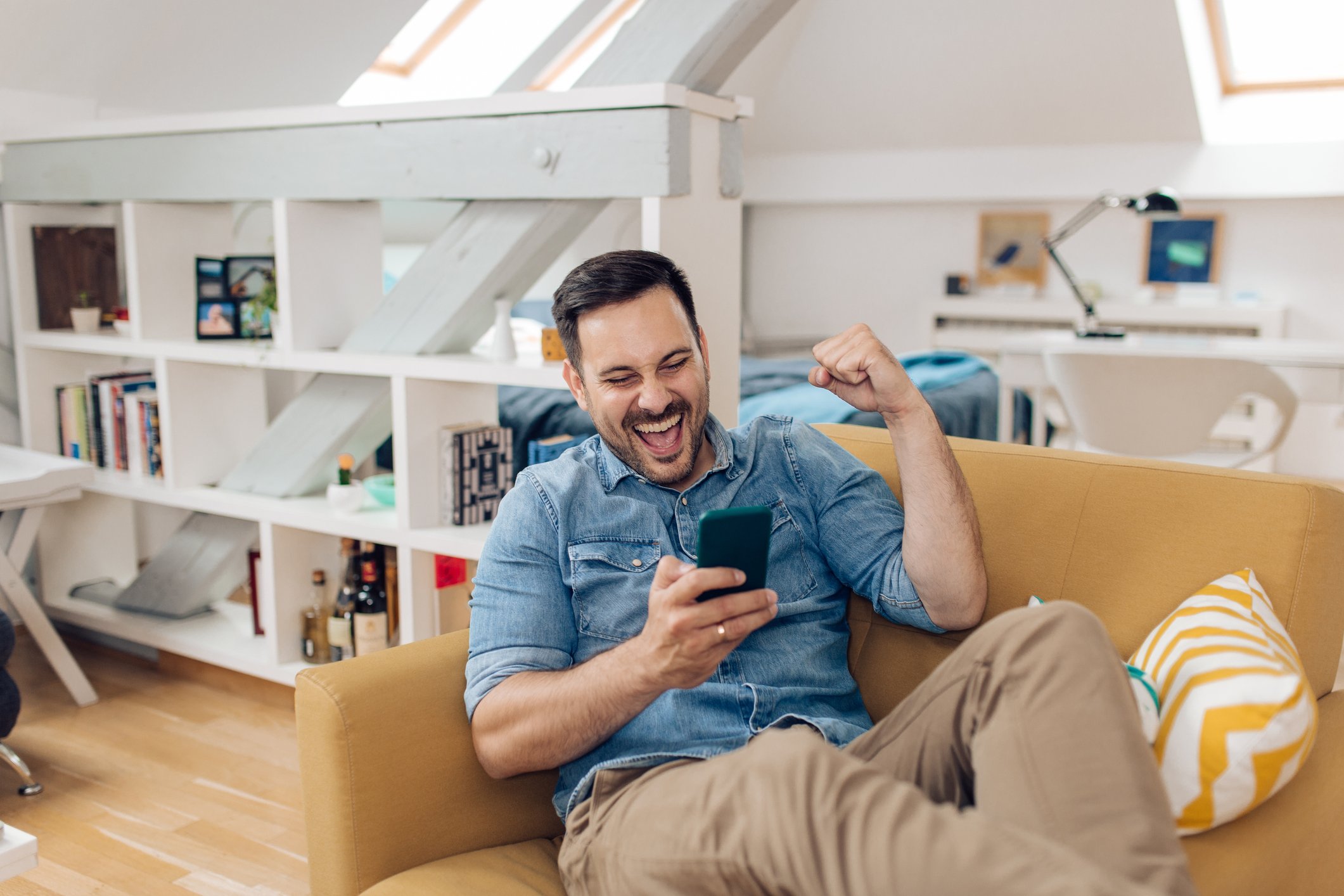 A person looking at their phone and cheering.