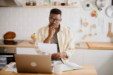 man looks a paper in front of computer getty 2022