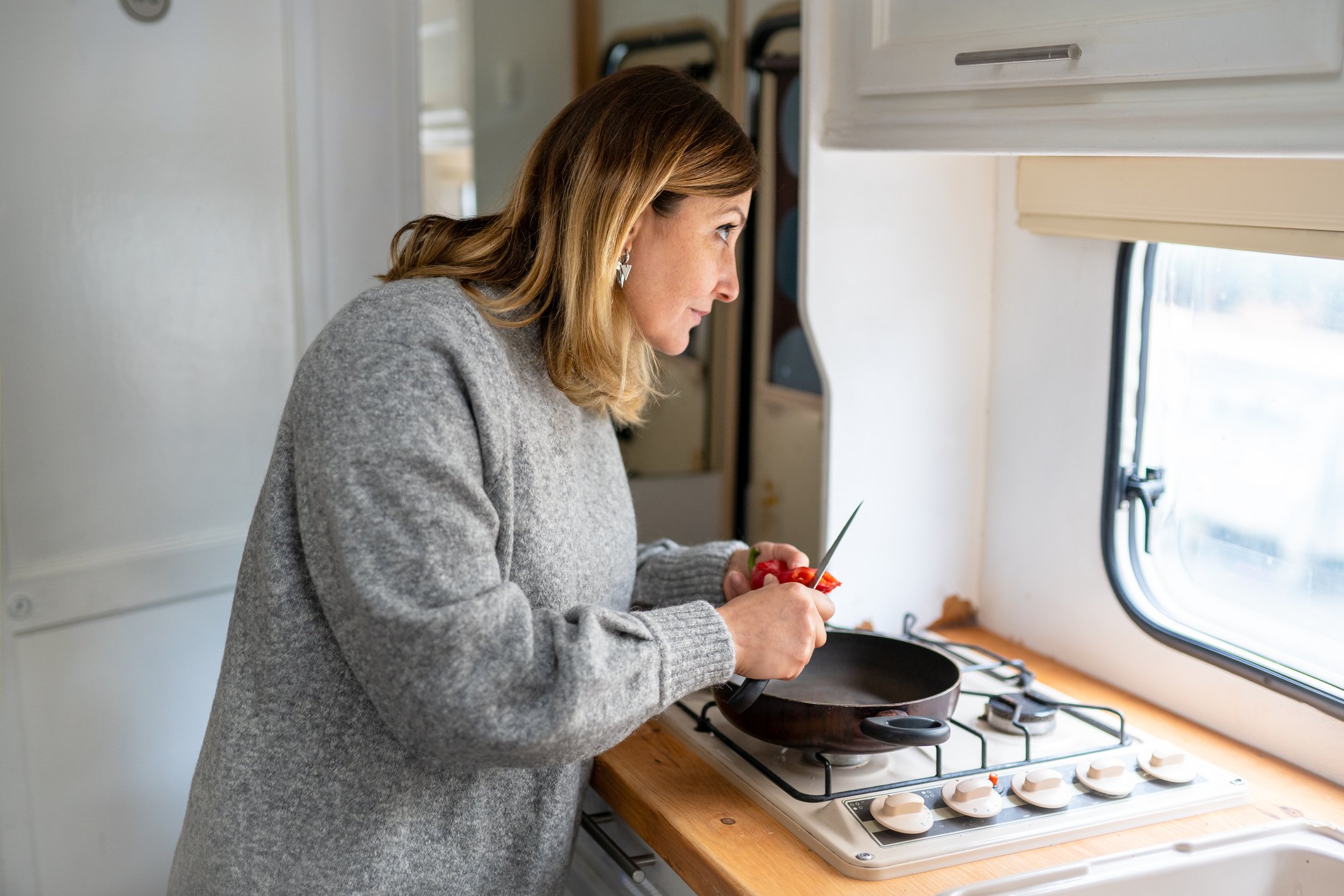Person at a stove inside an RV.