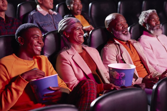 A group of people watching a movie in a movie theater.