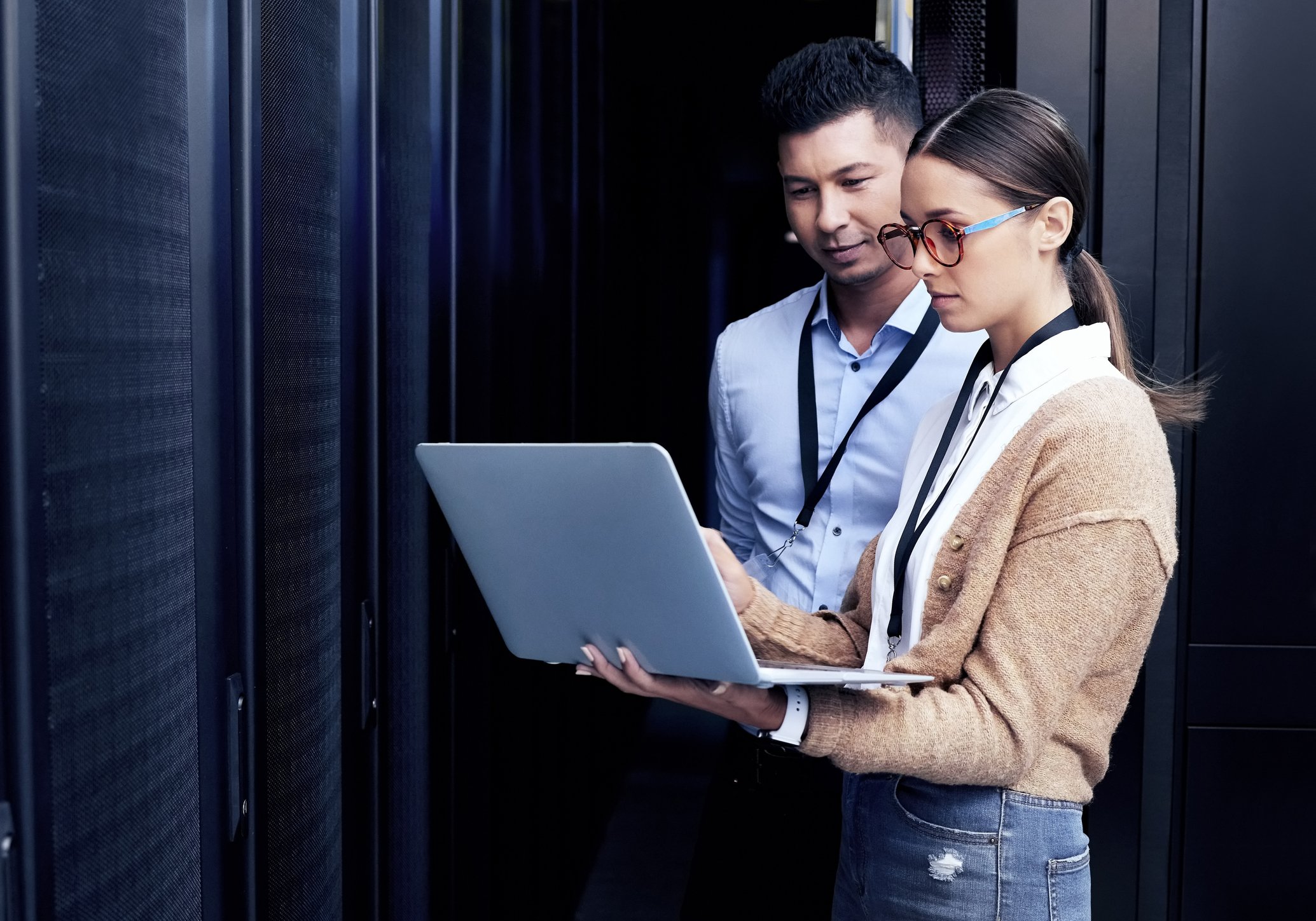 People using a laptop while inside a data center.