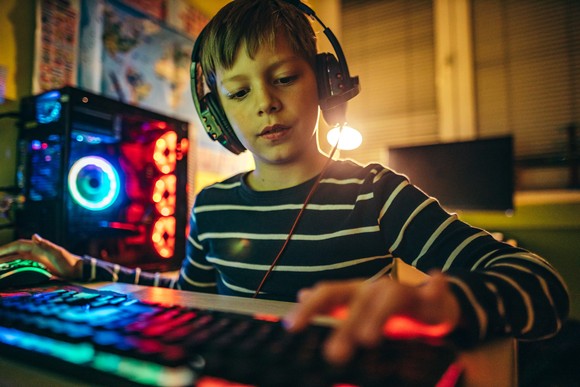 A kid playing video games on a PC.