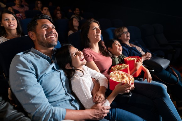 A group of people laughing in a movie theater.