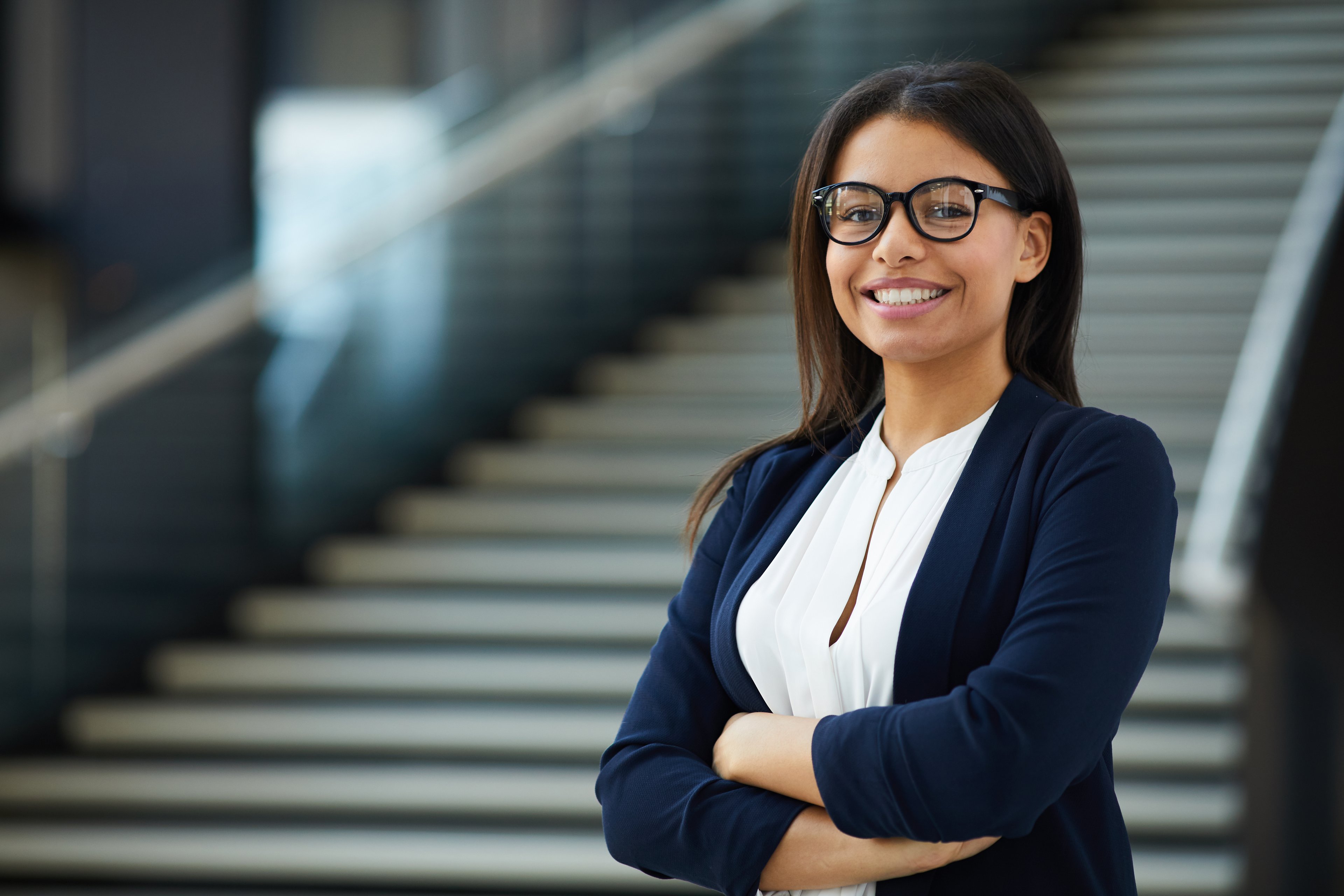Person in glasses standing in lobby.