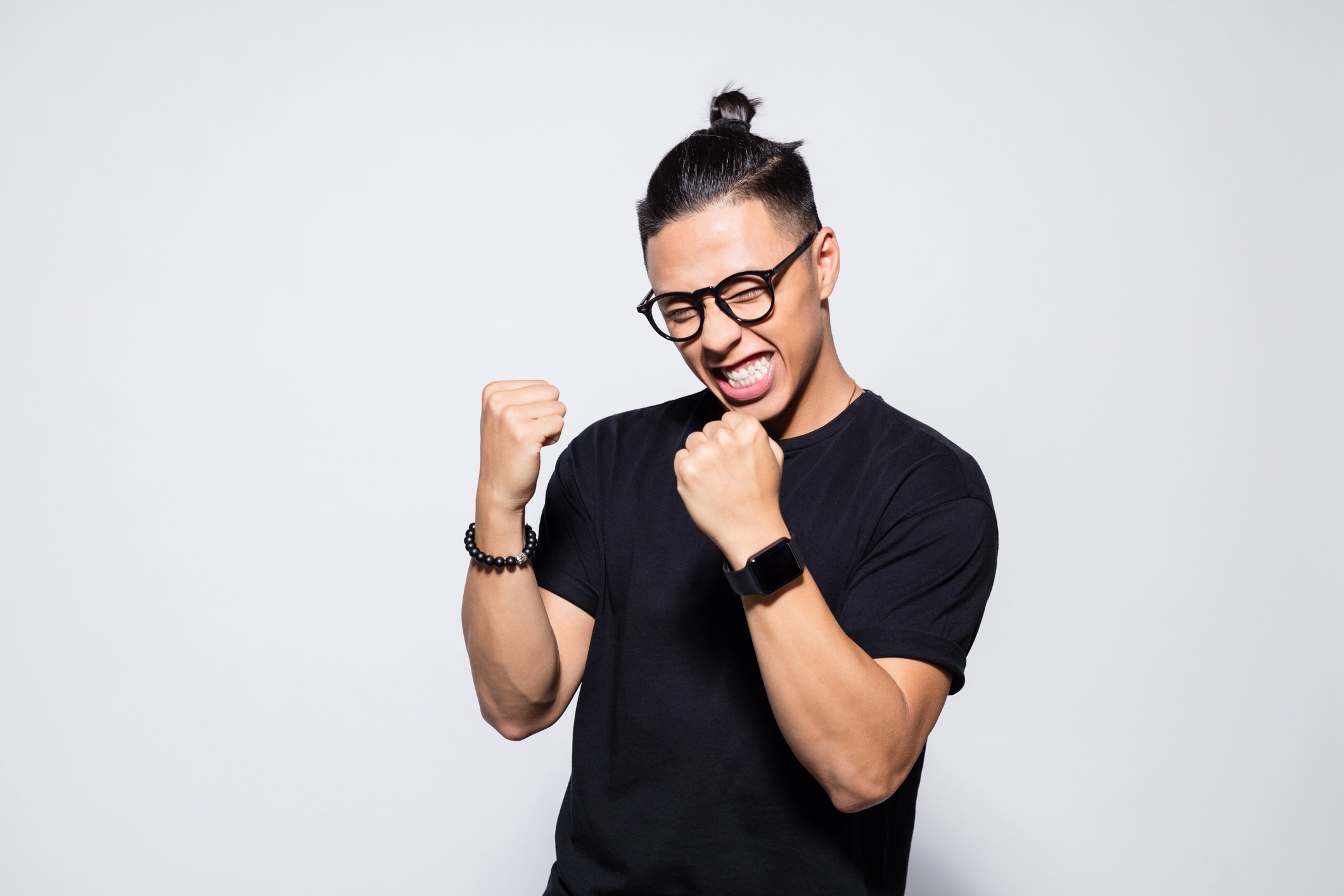 An excited person is making fists and smiling.