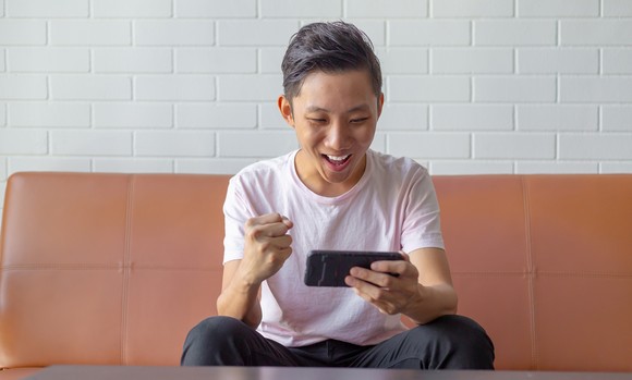 A person looking at their phone and cheering.