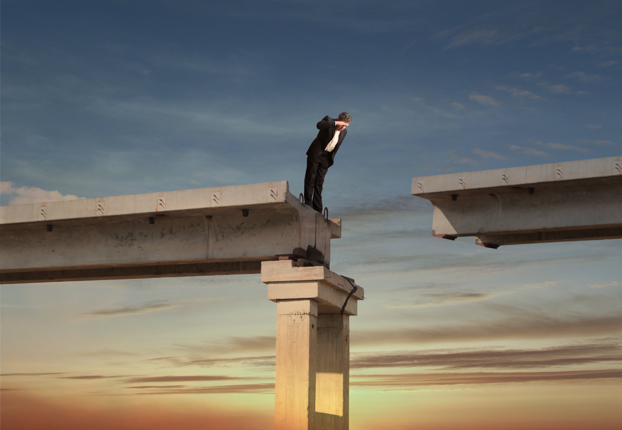 Person looking over the edge of a bridge.