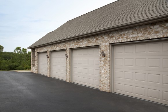 The outside of a garage structure, featuring four garage doors.