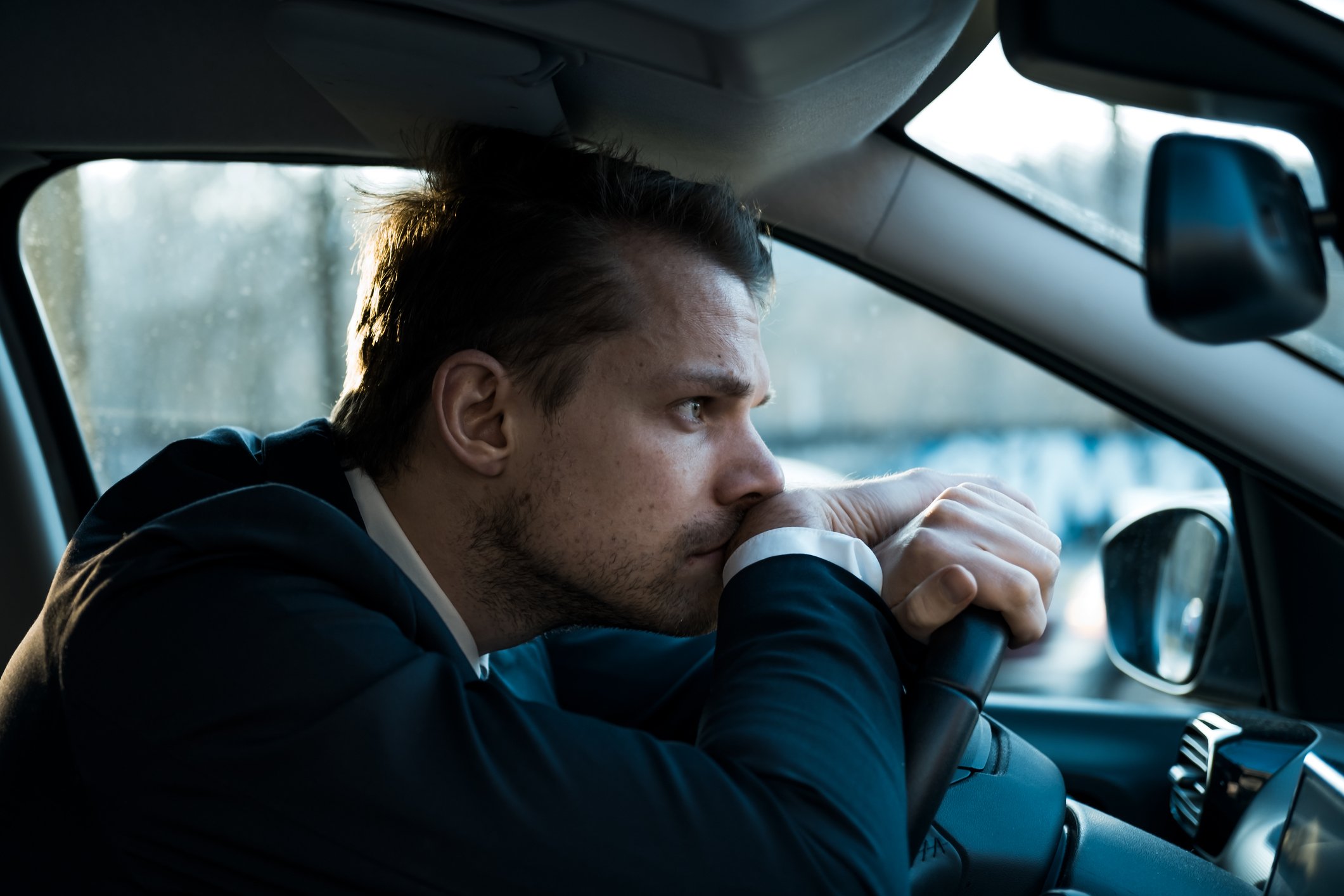 A distressed person sitting in a car.
