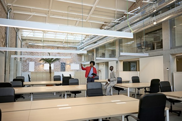 Two people touring an office space.
