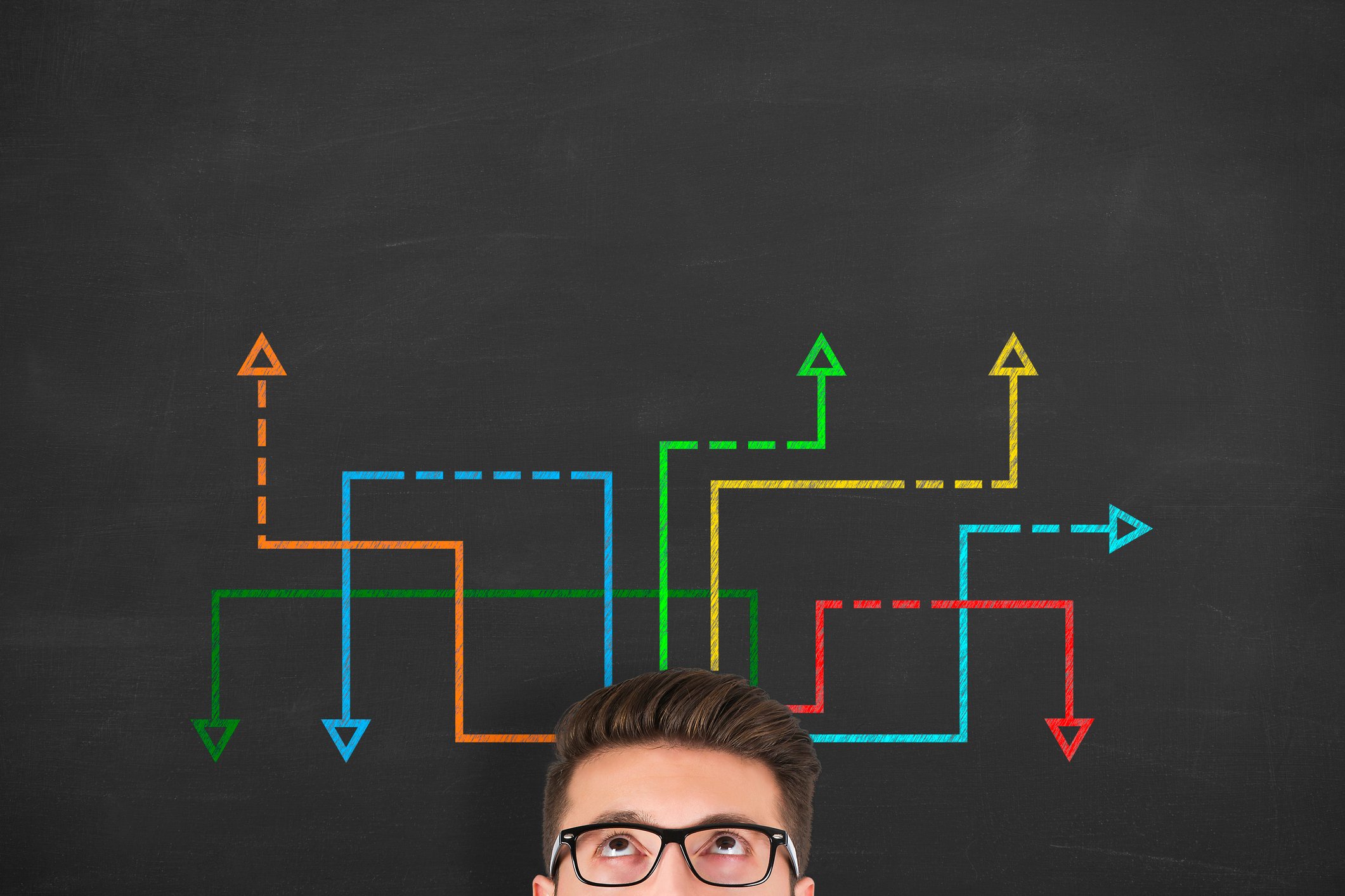 A person looks upward at several colorful arrows moving in different directions.