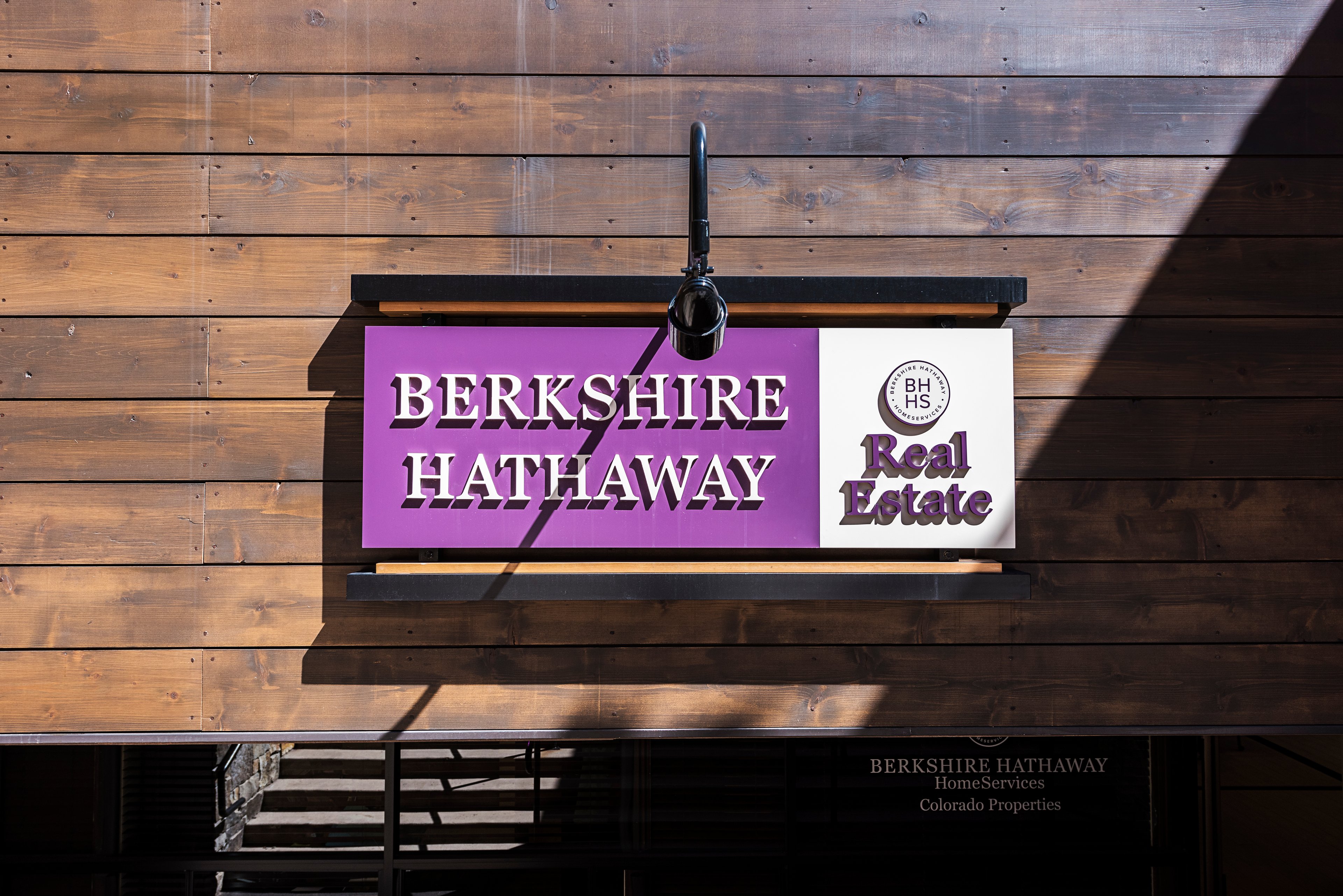 A Berkshire Hathaway Real Estate sign hanging on a wall.