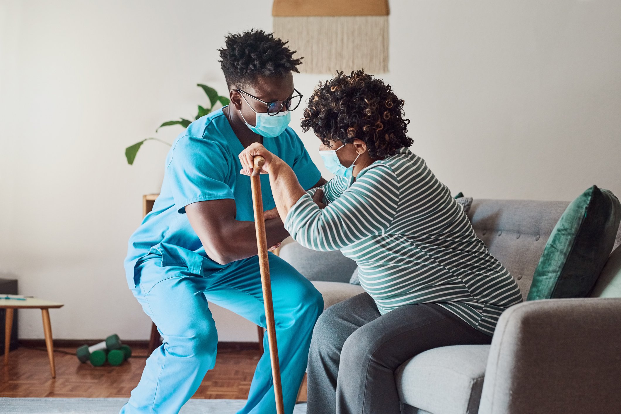 A nurse helping up a person with a disability. 