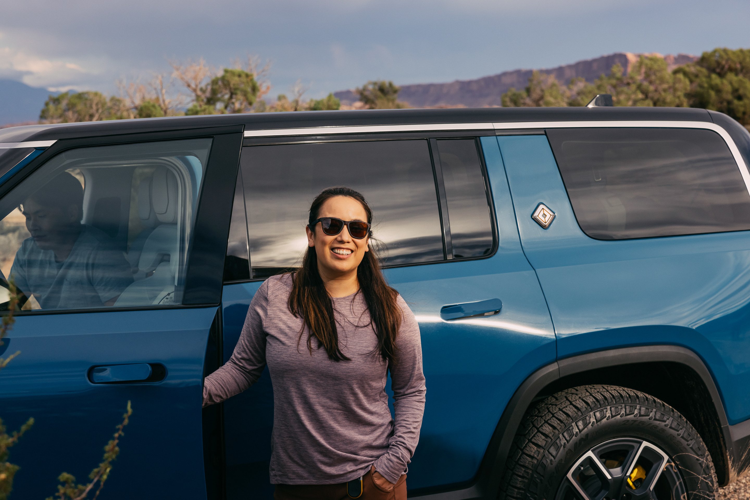 Person in front of Rivian R1S.