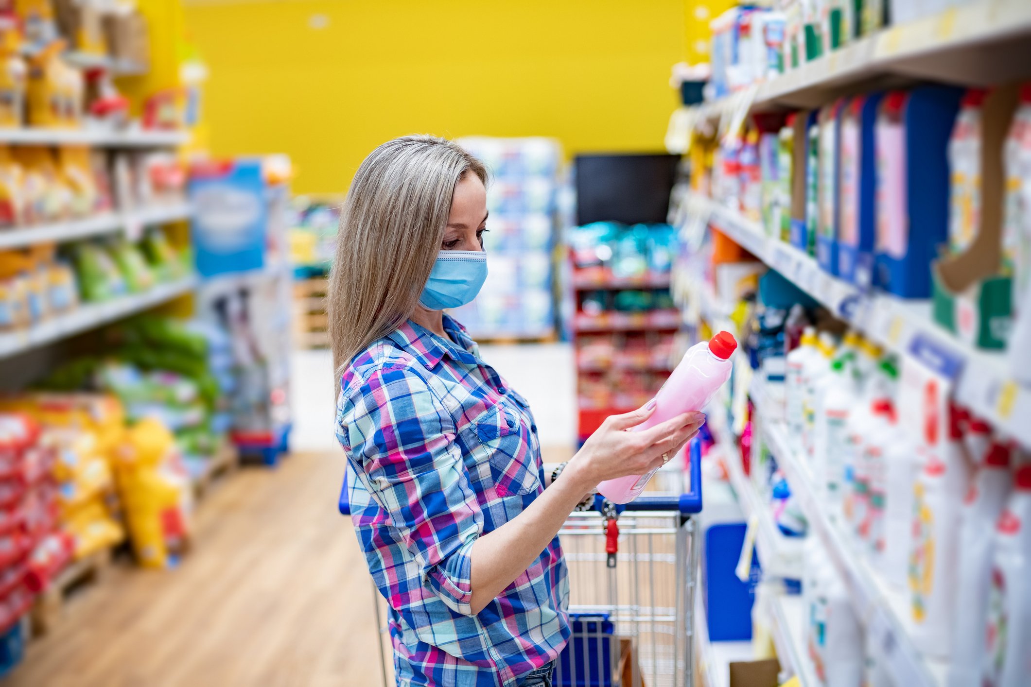A person in mask shopping for cleaning products.