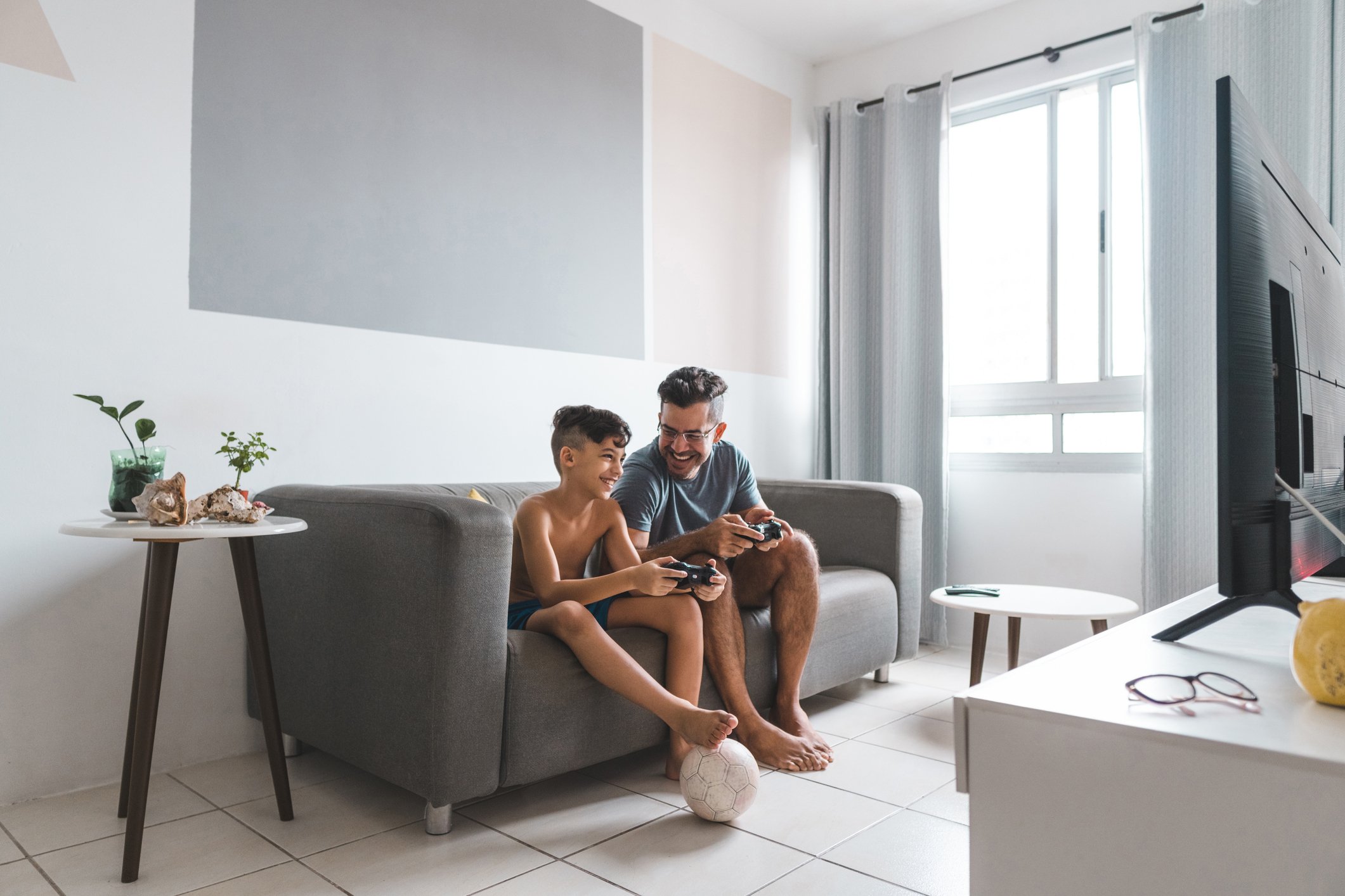 Two people sitting on a couch playing a video game.