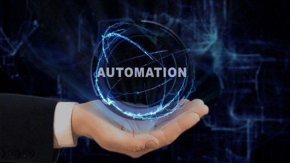 A hand holding up a sphere with "automation" written on it. 