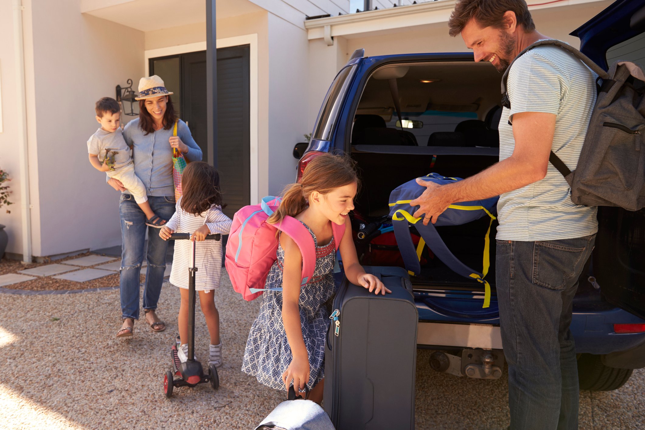 A family unloading luggage from a car.