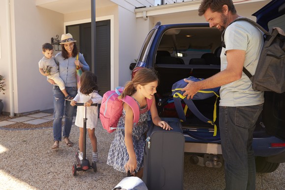 A family unloading luggage from a car.