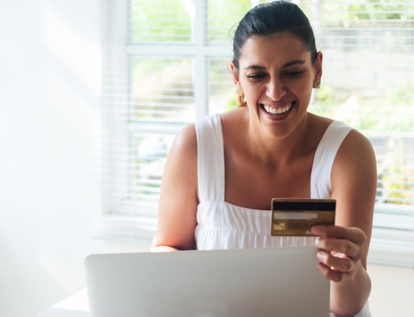 A person looks at a credit card on a computer 