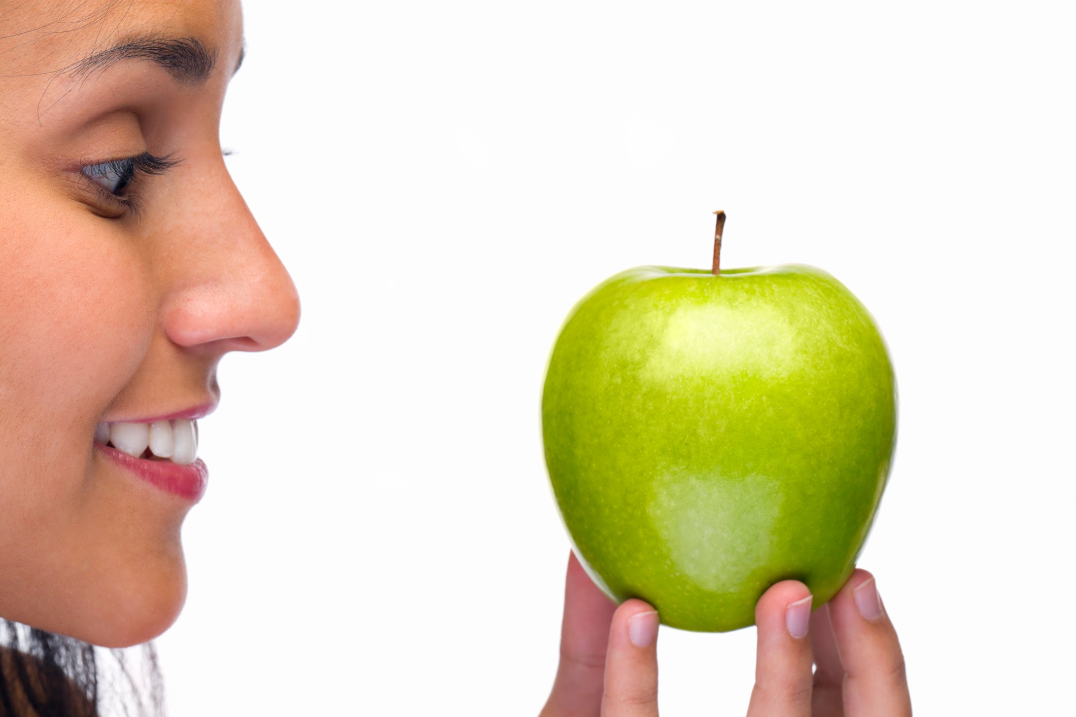 A person admiring a green apple.