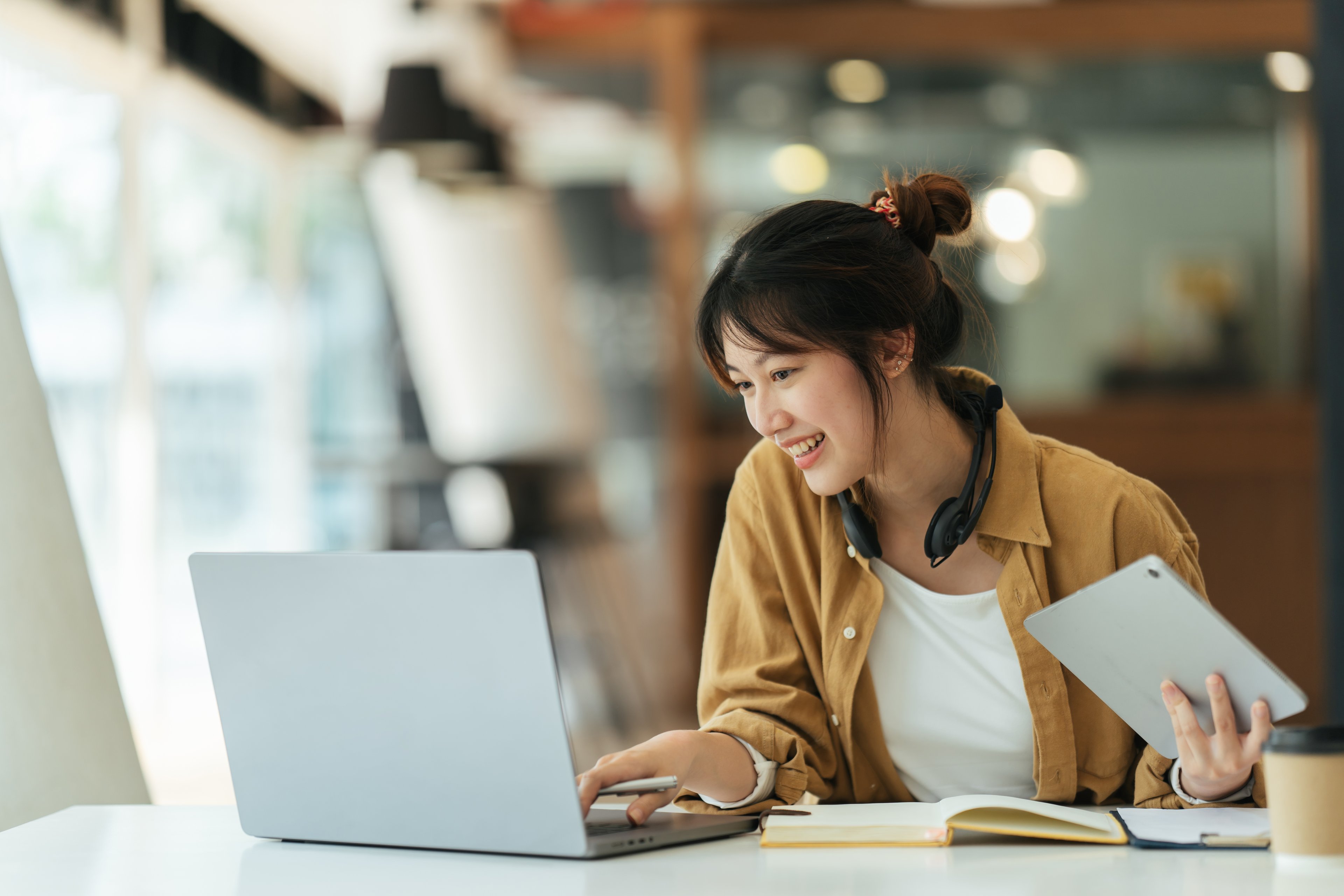 A person looking at a laptop and smiling. 