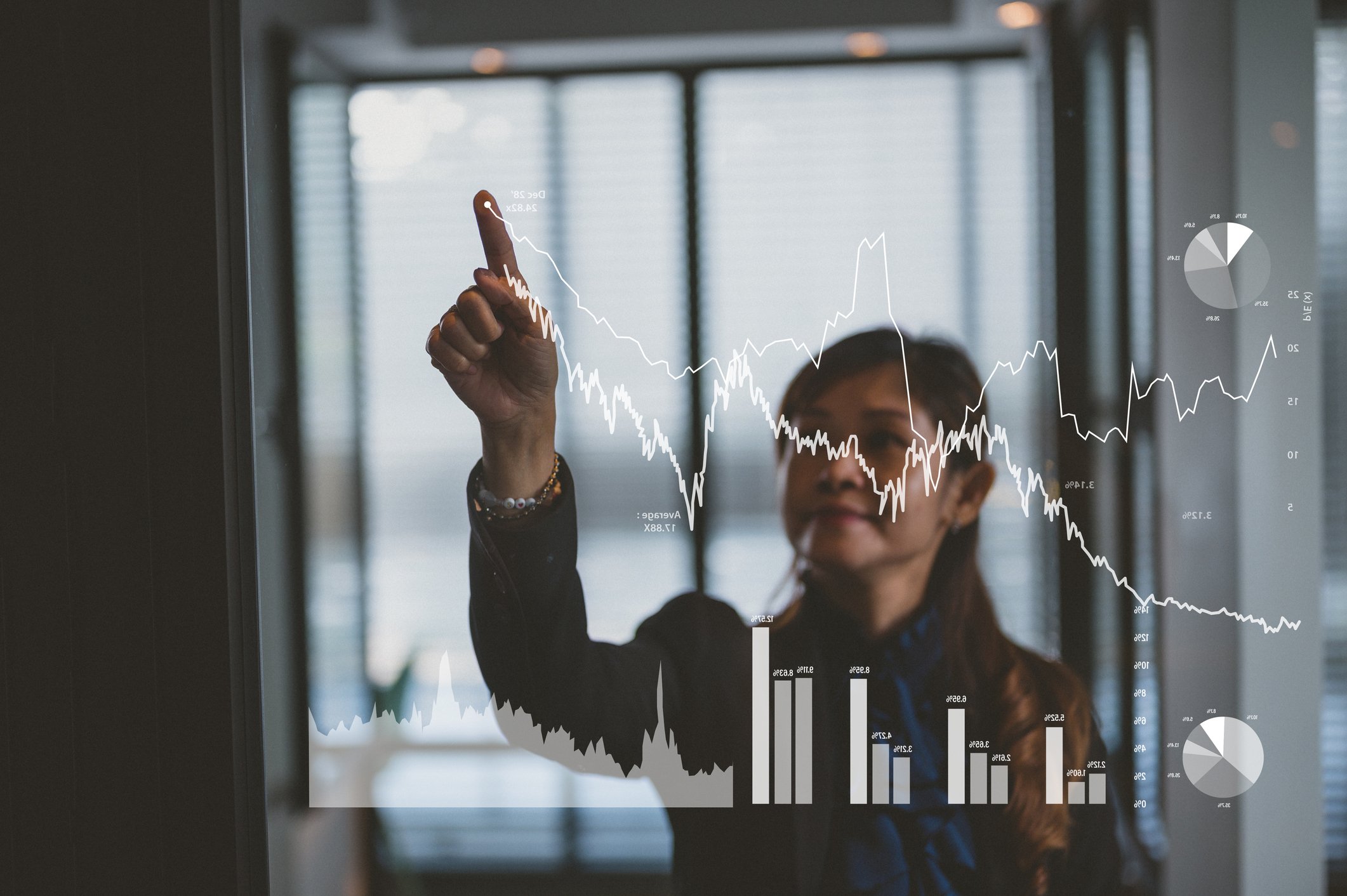 A person pointing to a chart trending upward.