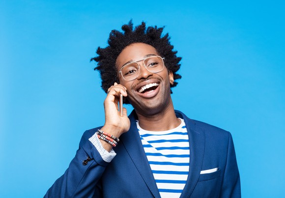 Person smiling and talking on their cell phone.