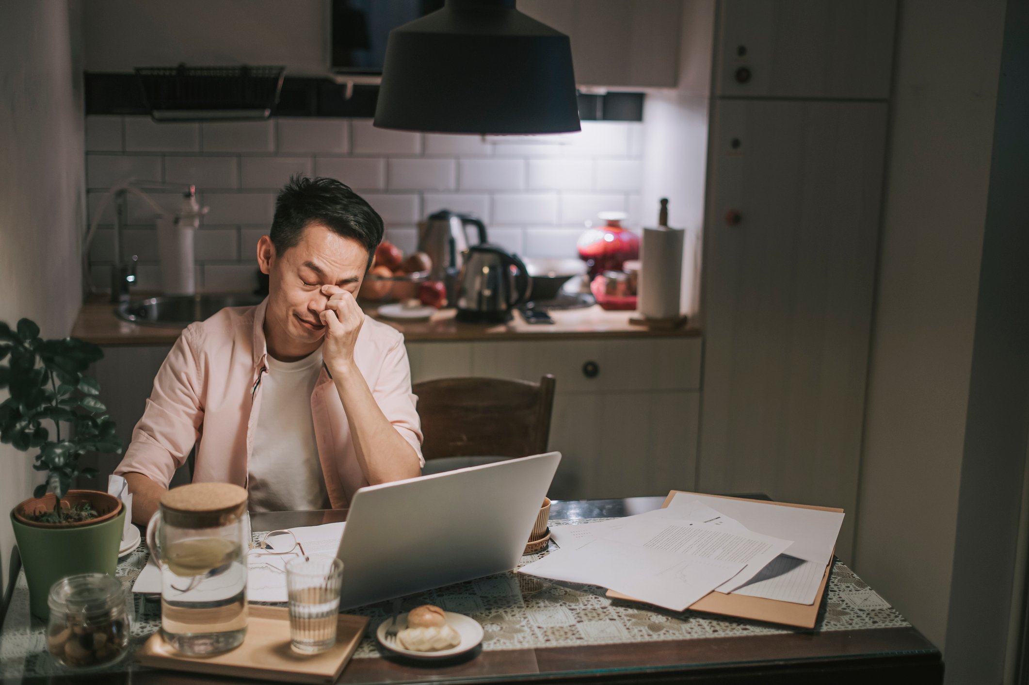 Man in front of laptop with worried expression.