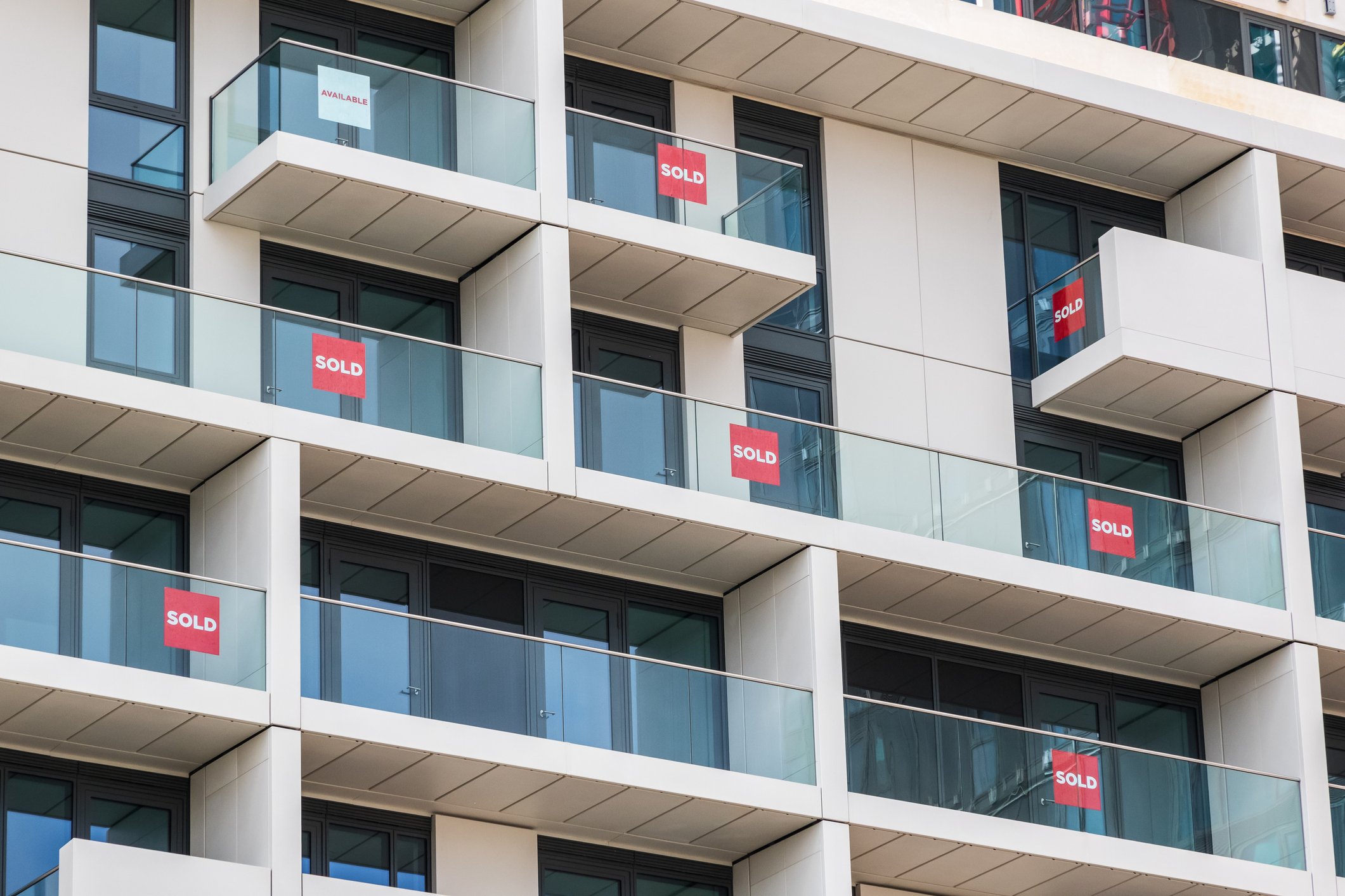 Condo building with sold signs on multiple balconies.
