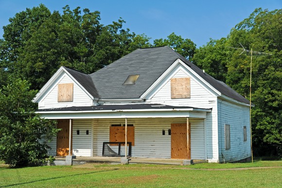 Boarded up single-family home sitting empty.