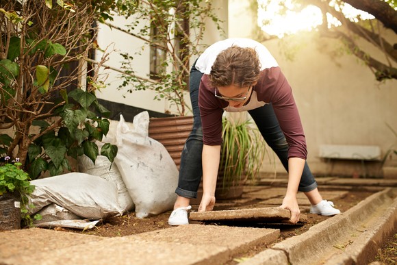 A person installing pavers.