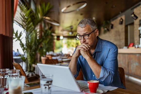 A person looking at their laptop, pondering data and information. 