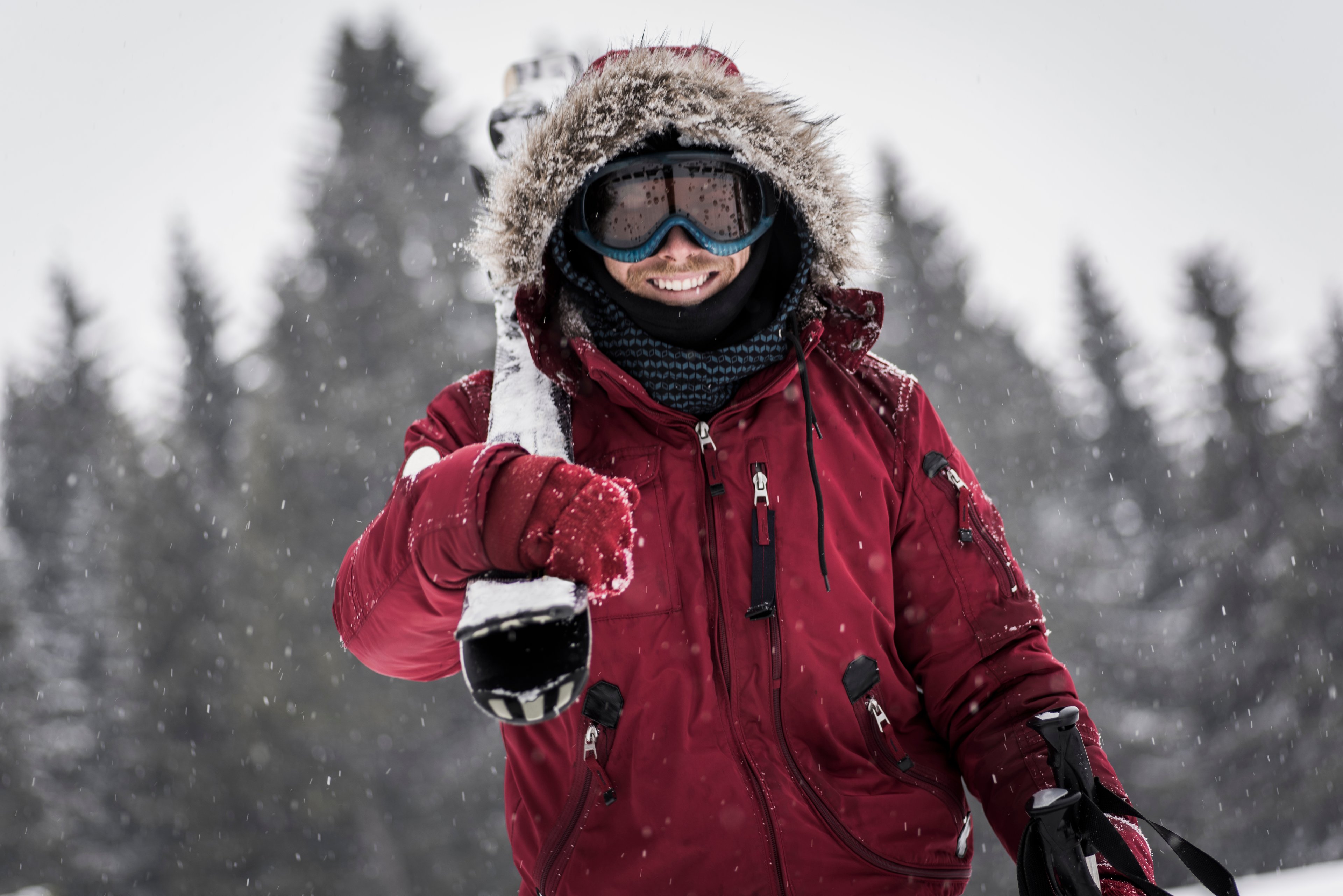 Person wearing winter parka in the snow, skiing. 