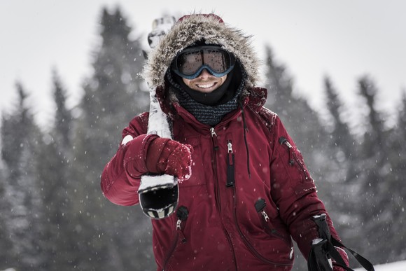 Person wearing winter parka in the snow, skiing. 
