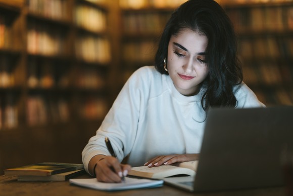 A person doing homework in a library.