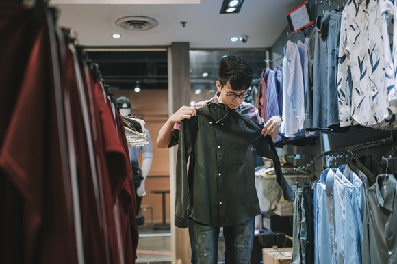 A person is shopping in an apparel store. 