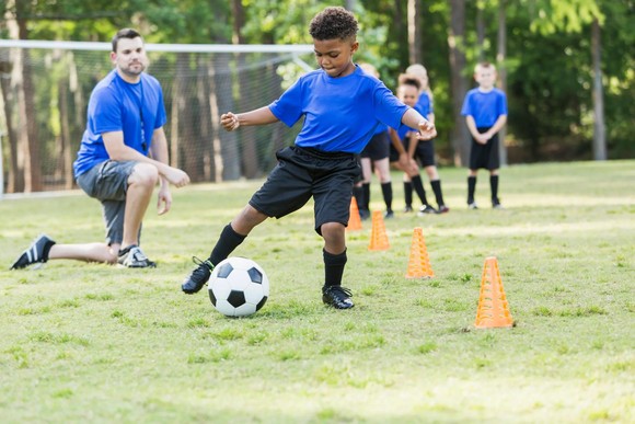 Young children doing youth soccer drills.
