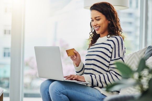 Consumer shops online while using a laptop at home. 