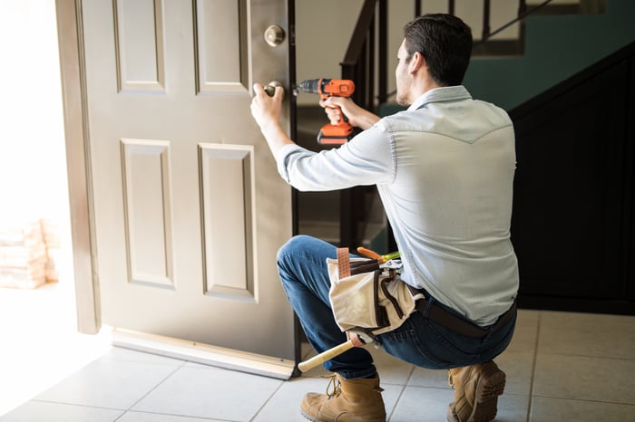 A handyman working on a door.