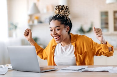 Overjoyed person looking at computer screen.