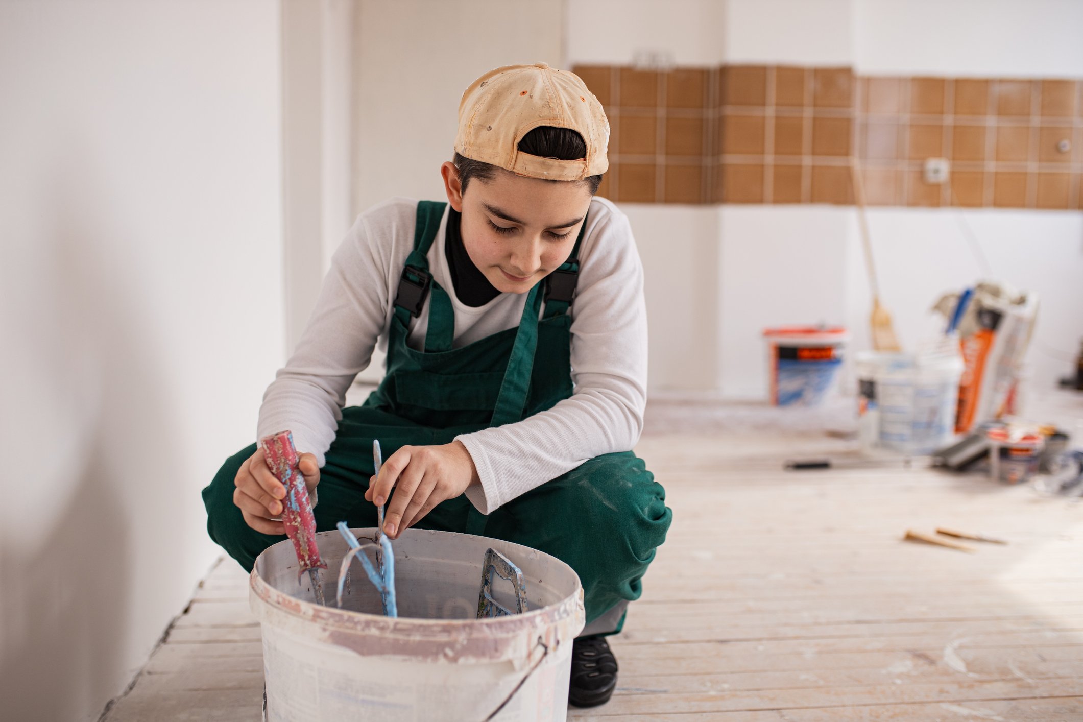 Person mixing wall paint in bucket. 