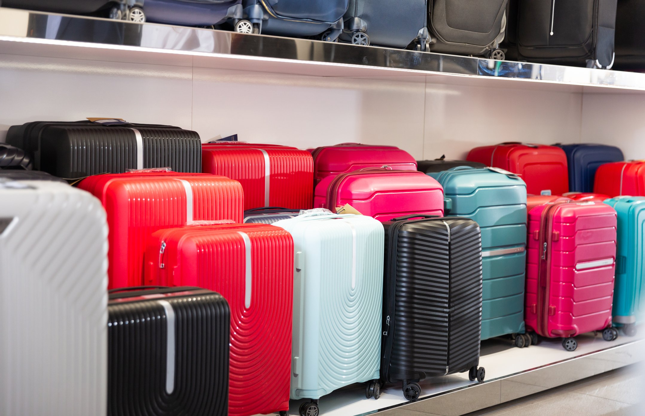 Luggage on shelves in a store.